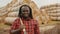 Portrait of young african farmer with pitchfork over his shoulder nodding his head as approval