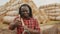 Portrait of young african farmer with pitchfork over his shoulder, thumb up