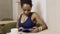 Portrait of young afroamerican lady, who is sitting in the cafe and looking to the tablet.