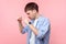 Portrait of young aggressive brown-haired man standing with clenched fists, ready to punch. isolated on pink background