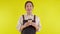 Portrait of young asian barista woman wearing apron smell coffee cup on yellow background.