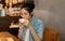 Portrait of young Asian gorgeous female with her eyes closed enjoying the smell of fresh delicious coffee at coffee shop