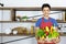 Portrait of young Asian handsome owner of restaurant, bistro or diner is smiling and holding vegetable basket in kitchen room