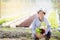 Portrait young asian man smiling harvest and picking up fresh organic vegetable kitchen garden in basket in the hydroponic farm