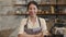 Portrait young Asian woman barista feeling happy smiling at urban cafe. Small business owner Indonesian girl in apron relax toothy