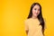 Portrait young asian woman, Beautiful girl wear yellow T shirt with yellow background, copy space at studio. Pretty asia female