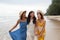 portrait of young asian woman with happiness emotion wearing beautiful dress walking on sea beach and laughing joyful use for