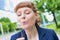 Portrait of young attractive businesswoman wishing on dandelion