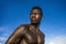 Portrait of young attractive and fit black afro American man with strong muscular body posing cool model attitude on the beach