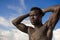 Portrait of young attractive and fit black afro American man with strong muscular body posing cool model attitude on the beach