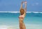 Portrait of young attractive and happy woman in bikini posing at amazing beautiful desert beach raising arms free enjoying Summe