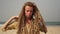 Portrait of a young attractive hippie woman with dreadlocks on the sea beach.