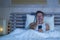 Portrait of young attractive man lying in bed tired and relaxed using mobile phone looking sleepy at his apartment bedroom in inte