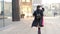 Portrait young attractive smile woman in hat and black coat walking down the street at city center feel happy fashion