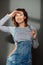 Portrait of young attractive stylish emotional smiling woman in jeans overalls