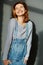 Portrait of young attractive stylish emotional smiling woman in jeans overalls