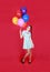 Portrait of a young attractive woman holding bunch of many bright balloons