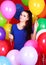 Portrait of a young attractive woman among many bright balloons