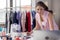 Portrait of a young, attractive woman on a stylish fashion designer`s table, surrounded by color textile samples. Attractive woma