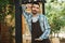 Portrait of young barista man smiling at camera while working in street cafe or coffeehouse outdoor