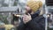 Portrait of young bearded Caucasian man in funny yellow hat and winter coat warming up with hot coffee outdoors. Frozen