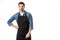 portrait of young bearded waiter in apron standing akimbo