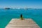 Portrait of young beautiful asian girl sitting at the pier looking at the ocean