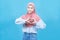 Portrait of young beautiful asian muslim woman in traditional dress make gesture love at heart isolated on blue background