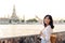 Portrait young beautiful asian woman smiling while travel at Wat Arun sunset view point, Bangkok, Thailand