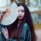 Portrait of young beautiful Asians in grey kimono and with a fan