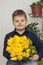 Portrait of a young, beautiful boy. Holds a huge armful of fresh yellow tulips. The concept of spring and holiday, March 8,