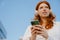 Portrait of young beautiful calm redhead girl in headphones