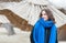 Portrait of young beautiful and cute girl in black coat and blue scarf outdoors on the cold weather with reed sunshades in the bac