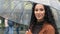 Portrait of young beautiful female carefree happy hispanic woman mixed race arabic girl with umbrella stands in city in