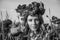 Portrait of a young beautiful girl in a poppy field with a wreath of poppies on her head on a hot summer sunny day