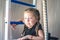 Portrait of young and beautiful gymnast in gymnastic leotard. Little girll goes in for sports on climbing frame. Sports child