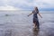 Portrait of young beautiful and happy Asian Chinese woman on her 20s or 30s wearing long chic dress walking alone on beach sea