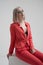 Portrait of a young beautiful informal blonde girl with dyed hair. Red jacket suit on the naked body. Studio photoshoot