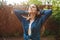 Portrait of young beautiful lady in denim shirt dreamily closing her eyes while standing under rain in park