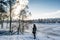 Portrait of a young beautiful red hair european girl standing near winter forest close to frozen river