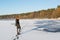 Portrait of a young beautiful red hair female crossing frozen river near forest