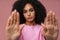 Portrait of young beautiful serious curly woman doing rejection gesture