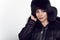 Portrait of young beautiful smiling model wearing trendy black leather zipped jacket and sable fur hat