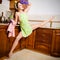 Portrait of young beautiful super flexible woman pinup girl in purple gloves at the kitchen with leg-split