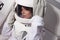 Portrait of a young beautiful woman astronaut, close-up. The woman in the suit screams