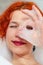 Portrait of a young beautiful woman in bathroom, looking through foam between fingers