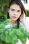 Portrait of a young beautiful woman in the foliage of spruce