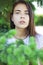 Portrait of a young beautiful woman in the foliage of spruce