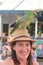 Portrait of a young beautiful woman with a green macaw standing over her hat in a nice bar in Bocas del Toro harbor