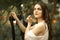 Portrait of young beautiful woman hanging washed clothes on a clothesline in the yard. Retro style photo.